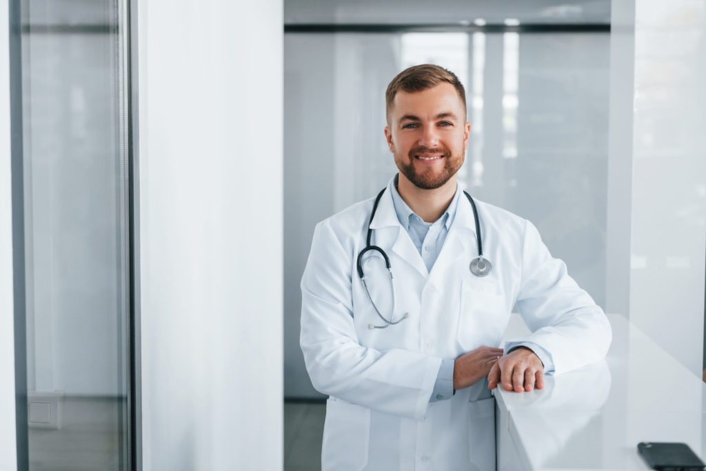 Front View. Professional Medic In White Coat Is In The Clinic - Verçosa Contabilidade Inteligência Fiscal LTDA